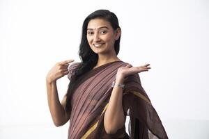 Positive Woman In Saree With Open Palm Pointing With Finger photo