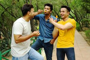 Indian male models are enjoying ice cream in the park. photo