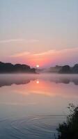 Misty Sunrise Reflection on a Tranquil Lake photo
