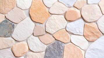 Irregular natural stone wall texture background with multi colored stones in soft warm tones used for architecture or design surface. photo