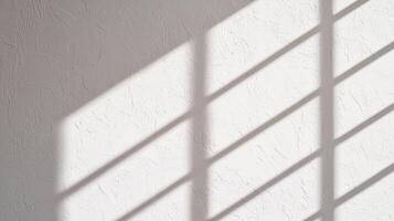 White plaster wall with harsh shadow lines cast by window creating contrast between textured surface and bright minimalist background. photo