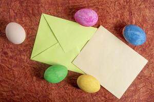 Colorful Easter eggs with a blank card on a textured background. photo