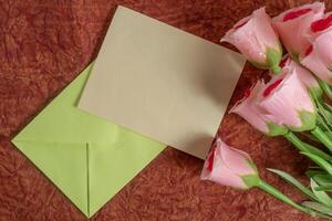 Soft pink roses with envelopes on a rustic background. photo