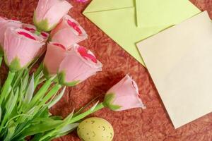 Beautiful pink roses and blank stationery on a textured background. photo