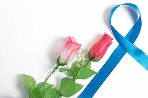 Pink and red roses with a blue awareness ribbon on a white background photo