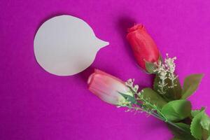 Romantic roses and speech bubble on a vibrant pink background for messages. photo