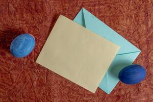Blank card and envelope with Easter decorations on a red background photo