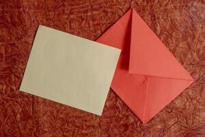 Elegant minimalist envelope and blank card on a red background. photo