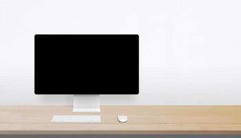 Minimalist desktop setup with wooden surface, blank monitor, and wide open space on the right for branding, advertising, or creative messaging photo