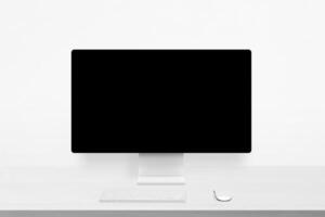 Minimalist white desk with computer monitor, blank display, keyboard and mouse, ideal for showcasing web interfaces, branding, or digital design work photo