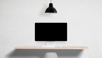 Desktop computer with blank screen on clean desk, overhead lamp and empty side space, perfect for UI mockups and marketing copy placement photo