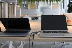 Table with laptops being prepared and set up for new employees in a company photo