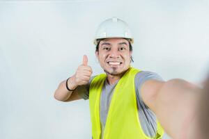 Self portrait of smiling engineer gesturing OK. Handsome engineer, smiling at the camera, showing approval photo
