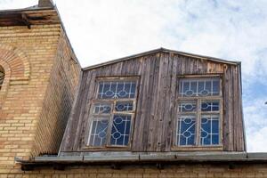 Old wooden attic above the roof of the house. Attic with windows photo