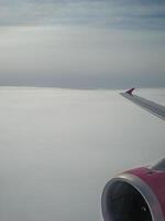 View of the clouds through the airplane window. Wing and turbine of a flying aircraft. The sky and the cloud. Travel, flight to fly photo