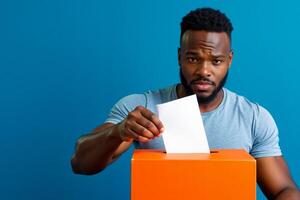 A man putting a piece of paper into a ballot box photo