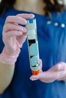 Doctor is demonstrating auto-injector syringe as an emergency treatment for allergic reaction. photo