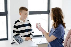 Boy testing breathing function by spirometry in doctors office. Diagnosis of respiratory function in pulmonary disease. photo