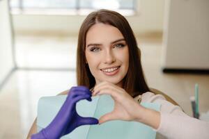 Doctor and patient are doing heart with hands in office. The doctor is grateful for trust photo