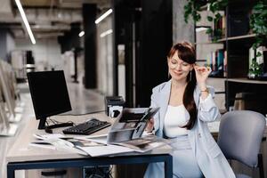 Businesswoman working at a desk in a showroom with tiles displayed. photo