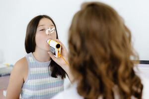 Girl testing breathing function by spirometry in doctors office. Diagnosis of respiratory function in pulmonary disease. photo