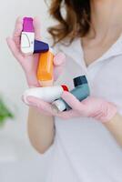 Female doctor holding and showing asthma inhaler. Medical portable equipment for asthma attack. photo