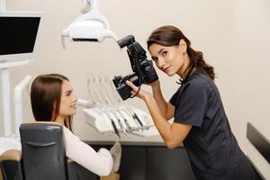 Woman photographing with professional camera the result of work in clinic photo