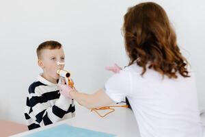 Boy testing breathing function by spirometry in doctors office. photo