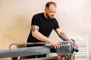 Construction worker using tile saw cutting machine preparing ceramic tiles for bathroom renovation photo