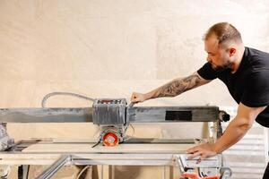 Construction Worker Using Tile Saw Cutting Ceramic Tiles. photo