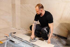 Tiler installing large format tile on bathroom wall using suction cup photo