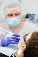 Dentist performing dental checkup on young patient photo