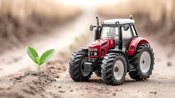 tractor stands next to a young seedling on the ground. The concept of children's play, agriculture, ecology and the growth of a new plant. photo