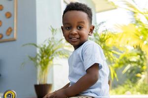 Smiling boy playing at home with plants in background photo