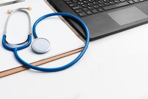 medical review chart next to a stethoscope next to a laptop with copy space. webinar concept. photo