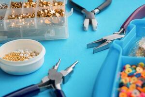Tools and accessories for creating elegant imitation jewelry on a background. photo