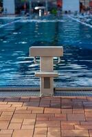 View of the starting block in the outdoor pool against the background of water photo