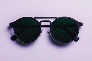 Modern black round sunglasses with tinted lenses displayed on a light background photo