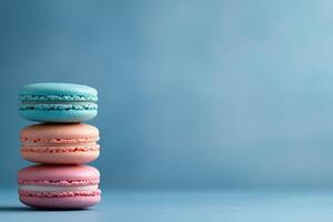 Colorful macarons stacked against a soft blue background creating a delightful dessert display photo