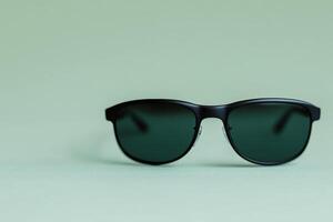 Stylish black sunglasses on a light green background create a modern look photo