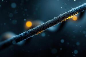 Close-up view of a textured wire covered in dew drops with glowing elements at night photo
