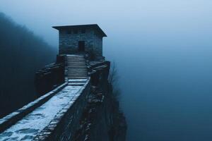 Mysterious stone building perched on cliff in foggy landscape at twilight photo