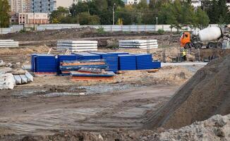 Concreting work at the construction site. Construction workers pour liquid concrete from cement concrete hopper to formwork installation. photo
