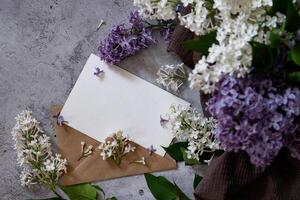 Composition of a beautiful spring lilac flowers on mint background. Mockup card invitation greeting card postcard copy space template. Branches of lilac blooming bouquet. photo