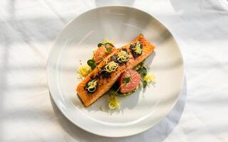 Pan seared salmon fillet with grapefruit avocado pur e delicate lemon zest and black caviar accents photo