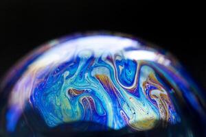 Abstract pattern, multicolored chaotic texture inside of the soap bubble, closeup photo
