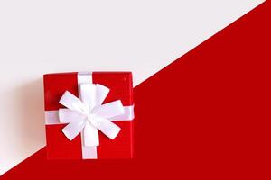 Red and white diagonal paper texture, red gift box with white bow photo