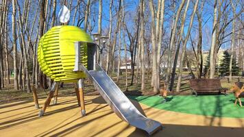 Modern playground with unique slide and spring riders in leafy park photo