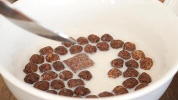 Cereal in milk displayed in a bowl with spoon on a wooden table video