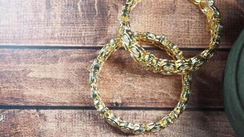 Elegant gold bangles displayed on wooden surface video